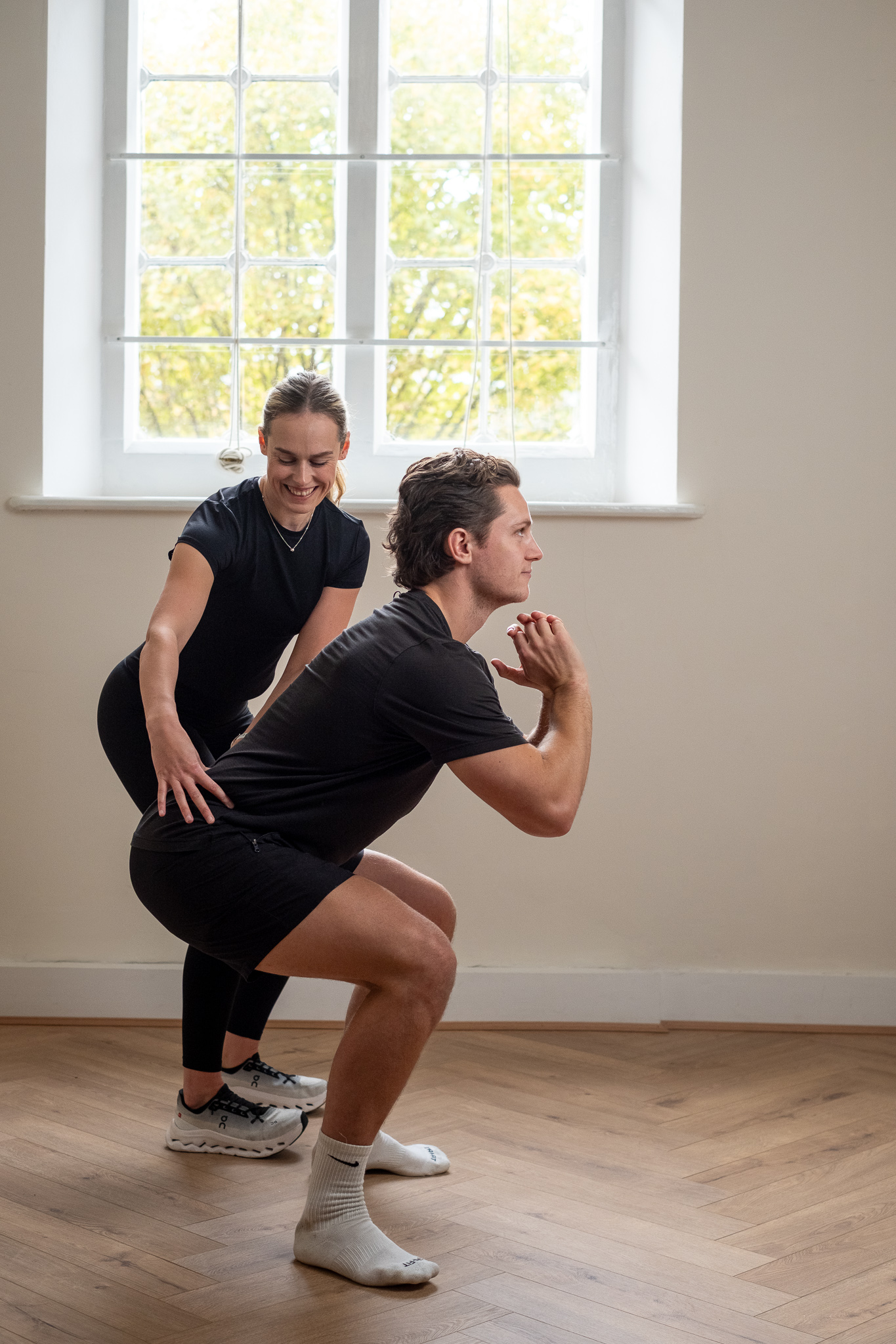 Personal trainer coaching client during squat exercise